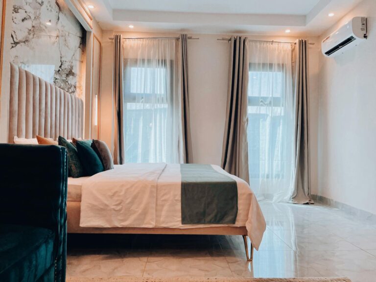 Chic hotel room interior design featuring a stylish bed, curtains, and natural light.